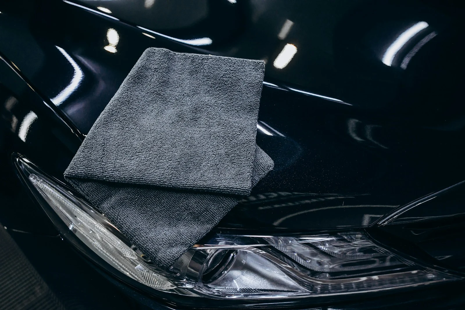Gray microfiber cloth on a black car hood